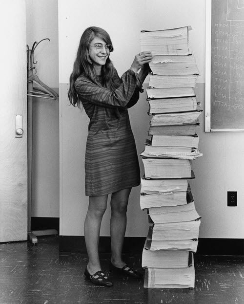 Hamilton in 1969, standing next to listings of the Apollo guidance software she and her MIT team produced